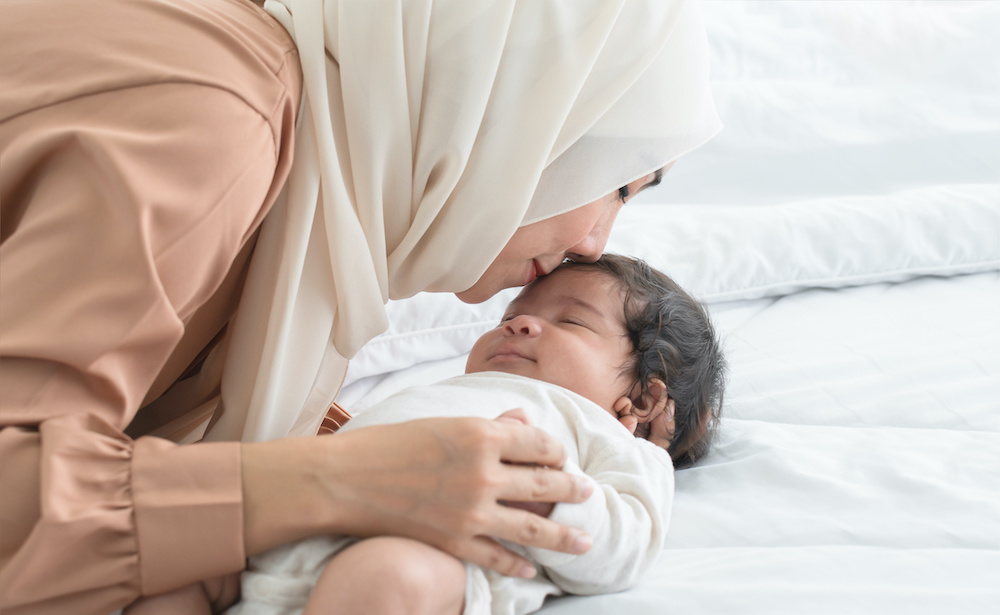 Mother holding her infant after circumcision care at Precision Circumcision Clinic