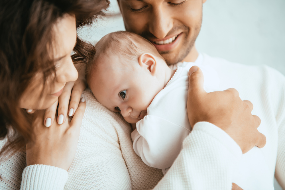 Mother and father hugging their baby after care at Precision Circumcision Clinic in Bankstown